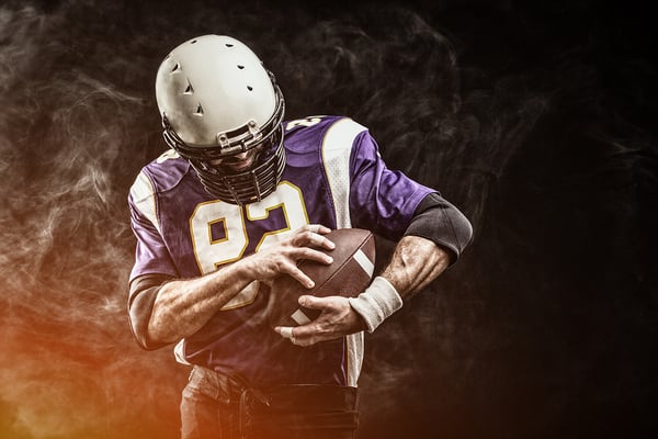 American Football player holding football