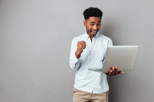 BS Black male celebrating success alone on laptop.jpg