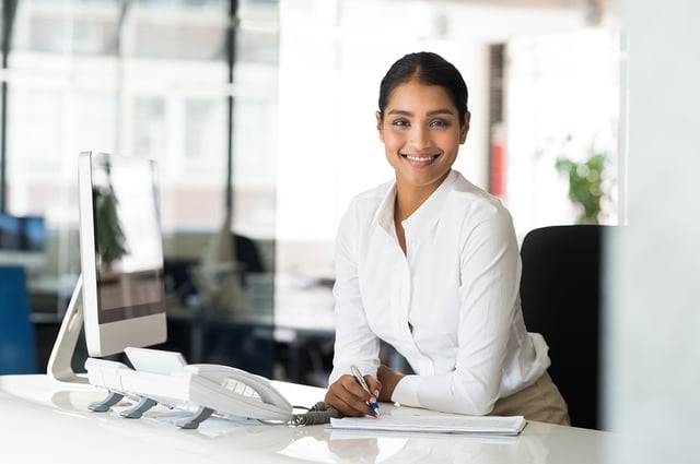Smiling East Asian Professional woman at desk