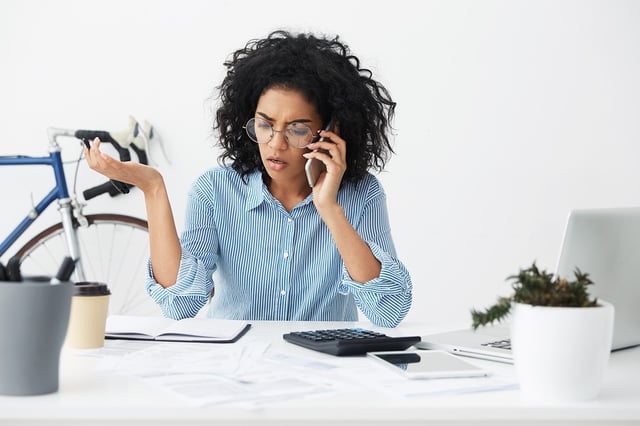 Stress signs African American women trying to multitask at desk