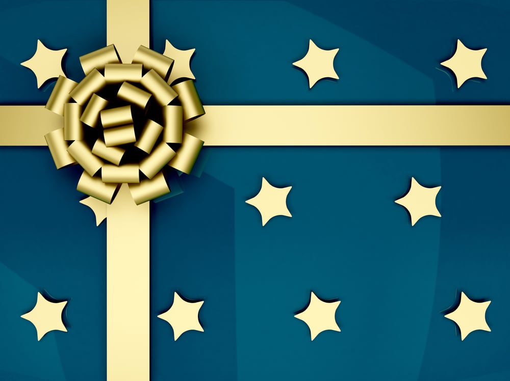 Christmas present wrapped in blue with golden stars and ribbon