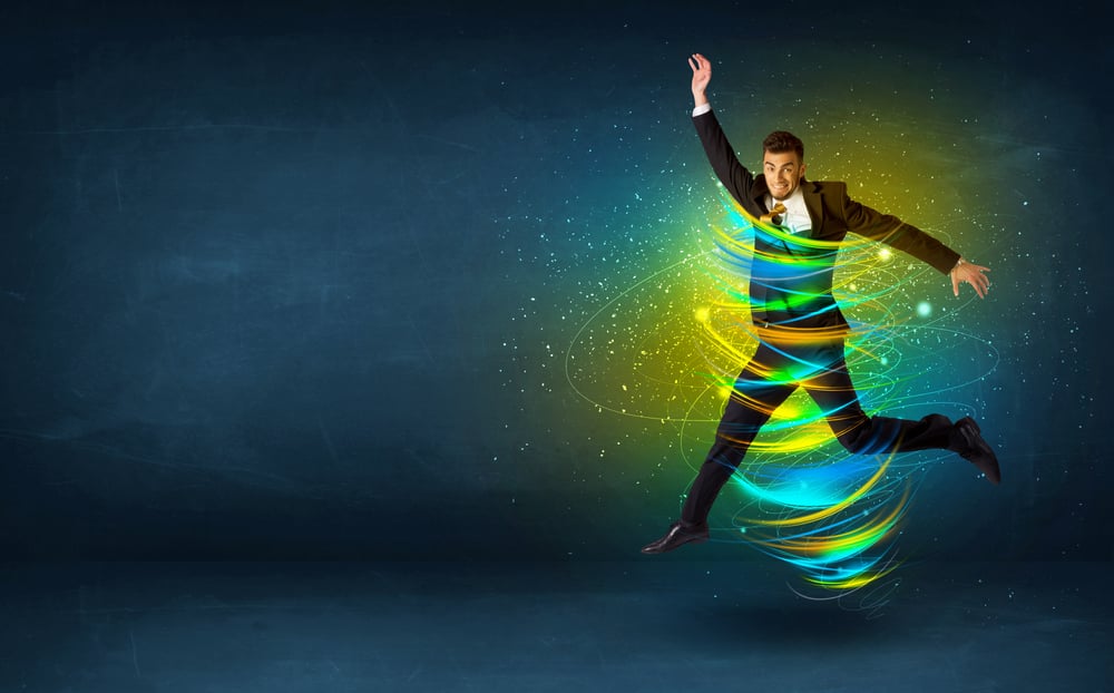 Excited business man jumping with energy colourful lines around him