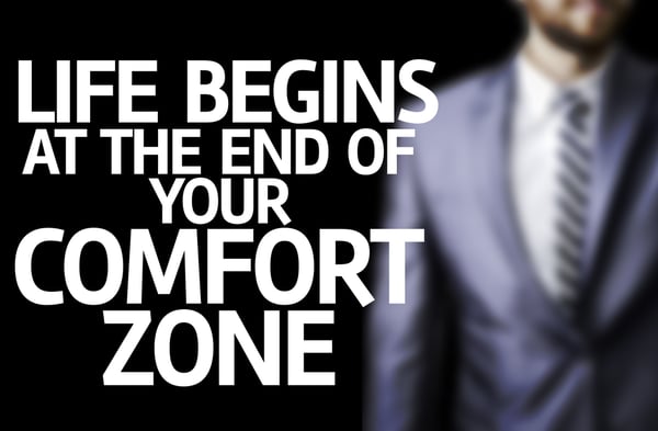 Life Begins at the end of Your Comfort Zone written on a board with a business man on background