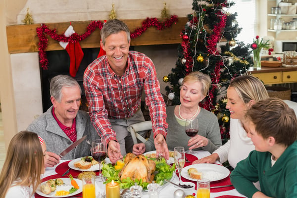 Man serving roast turkey at christmas at home in the living room