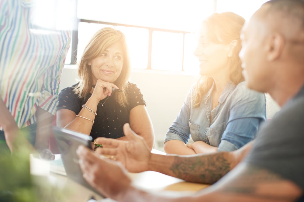 Unposed group of creative business people in an open concept office brainstorming their next project.